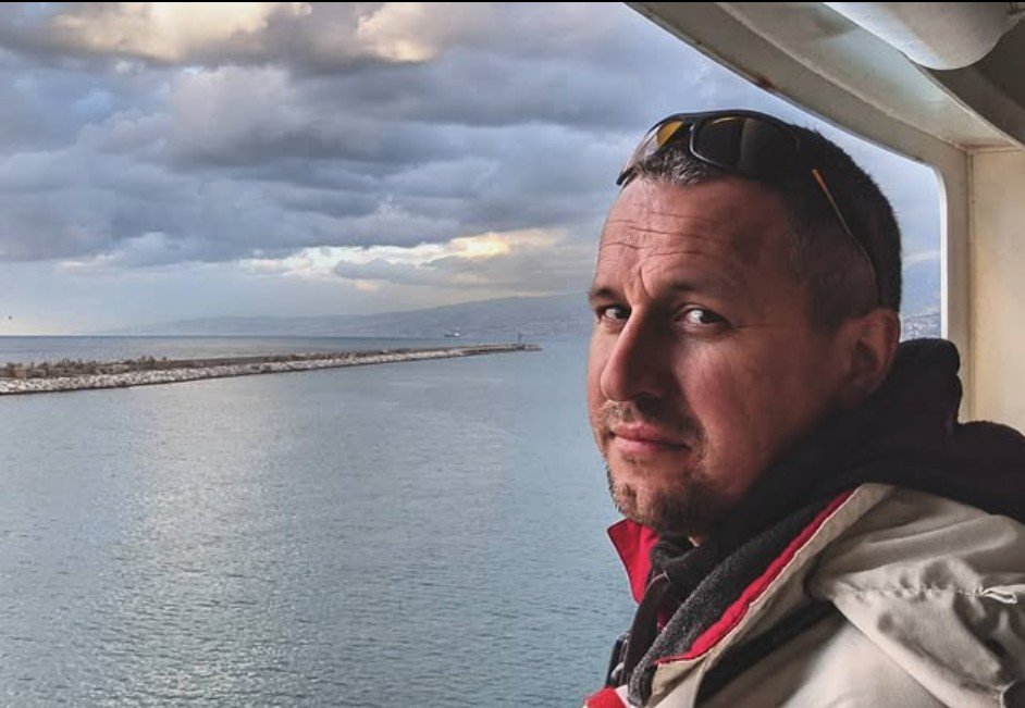 Vitalii Markov on a cargo ship, sea and breakwater behind
