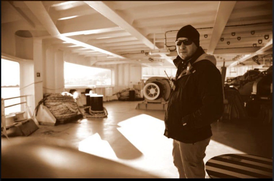 Cargo ship deck: mooring lines, winches, Vitalii Markov with a radio